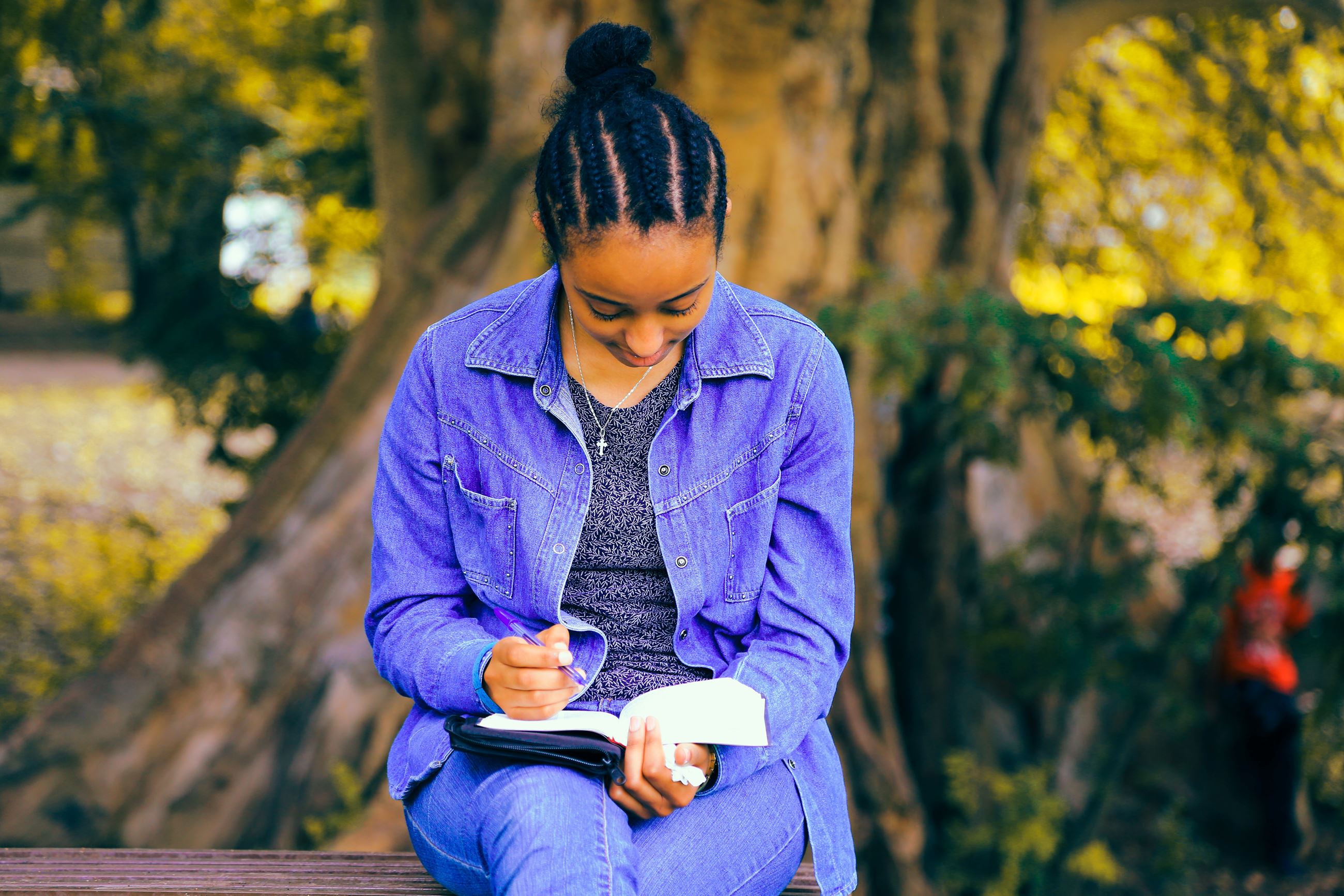 Photo by Gift Habeshaw on Unsplash. A girl writing in a journal on a park bench under a tree. Photo by Gift Habeshaw on Unsplash. A girl writing in a journal on a park bench under a tree.