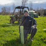 Ryan Bird next to a newly planted tree at South Prairie Creek Preserve.