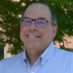 Mark facing forward in front of a tree.
